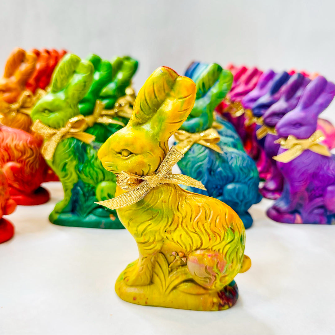 Handmade Easter Bunny rainbow crayon. This bunny crayon is mostly yellow featuring a swirl of vibrant colors, perfect for cute Easter basket gifts for kids. This handmade rainbow crayon is shaped like a traditional chocolate bunny and tied with a gold ribbon, making it a fun and unique alternative to candy. A perfect non-toxic, creative Easter gift from Art 2 the Extreme® and a top gifts for Easter!