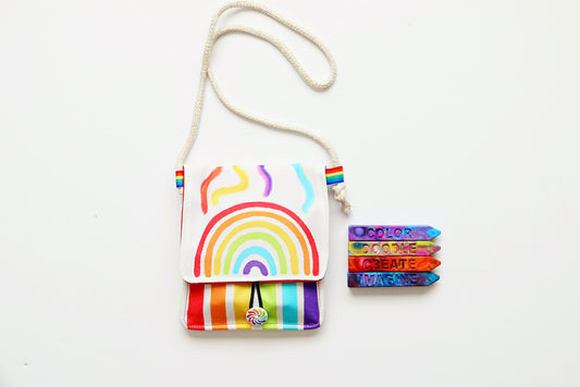 Rainbow purse for little girl is white with a rainbow design on the front. Four custom rainbow crayons are included that say COLOR, DOODLE, CREATE, and IMAGINe.